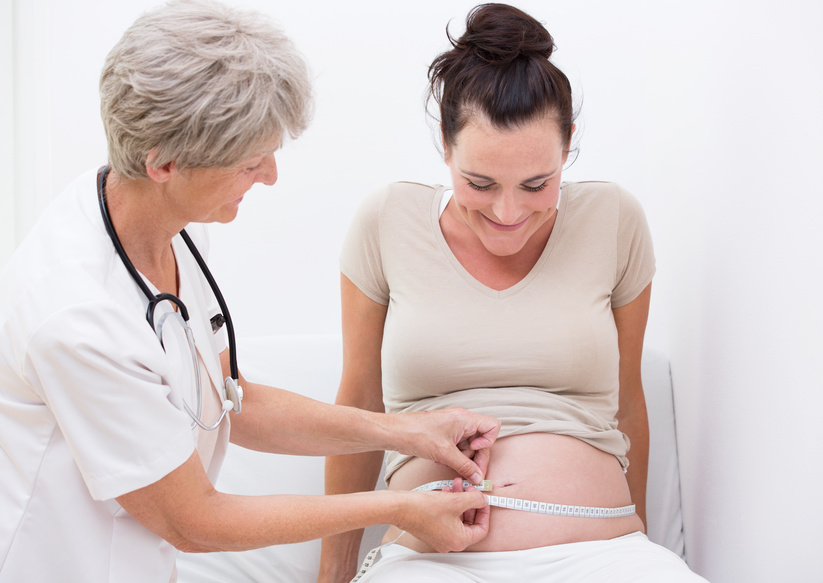 Hebammentätigkeit Schwangerenvorsorge Hebamme misst den Bauchumfang